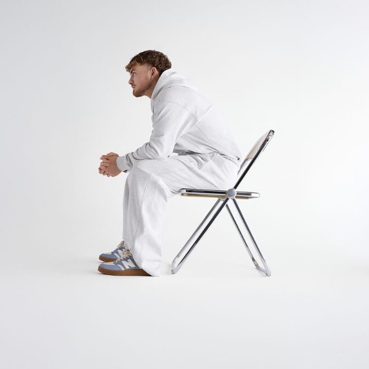 Person sitting in a chair wearing new balance shoes
